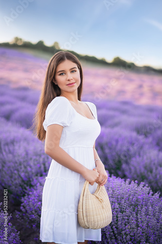 Beautiful girl on the lavender field. Beautiful woman in the lavender field on sunset. photo