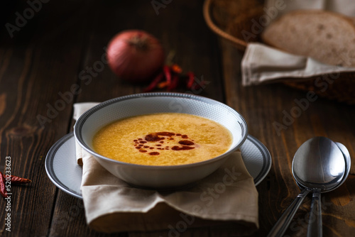 Turkish traditional lentil soup mercimek corbasi on dark wooden background. photo
