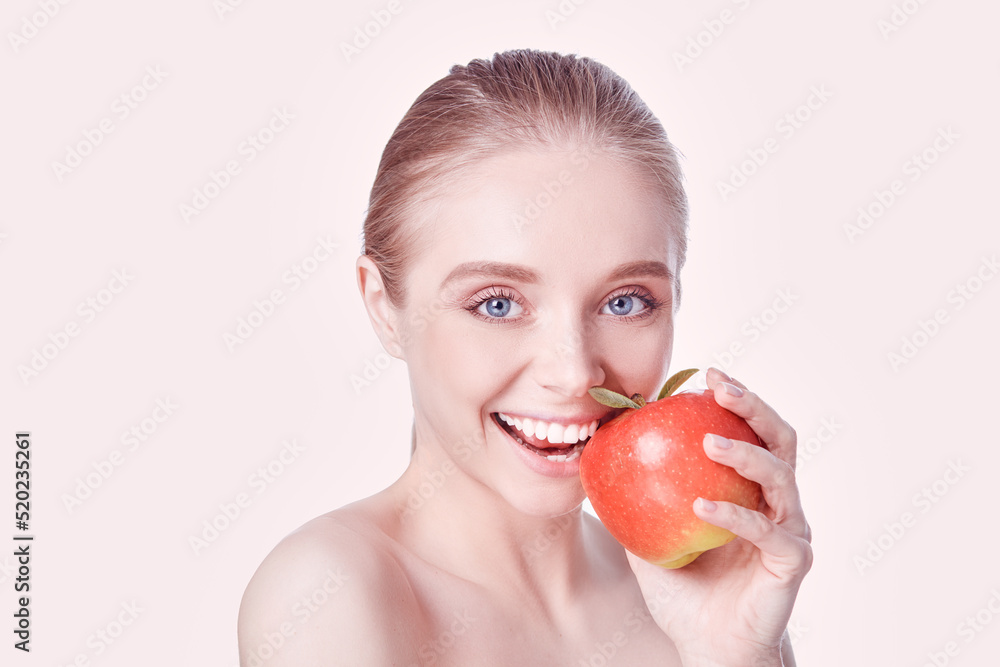 Portrait of happy smiling young beautiful woman eating red apple, over white background Portrait of happy smiling young beautiful woman eating red apple, over white background