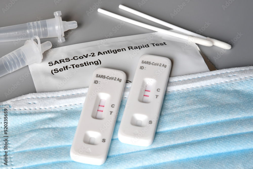Two SARS-CoV-2 Antigen Rapid Tests (Self Testing) kits that showing positive results on protection masks Two SARS-CoV-2 Antigen Rapid Tests (Self Testing) kits that showing positive results on protection masks
