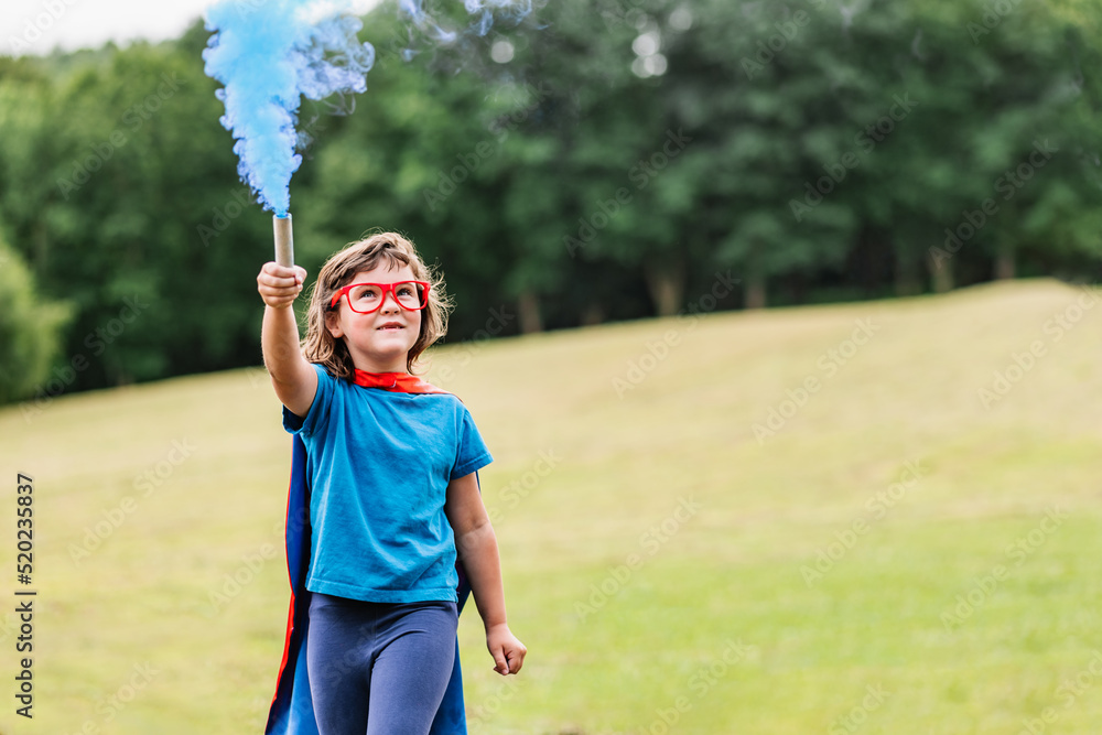 Little superhero waving blue smoke bomb Little superhero waving blue smoke bomb