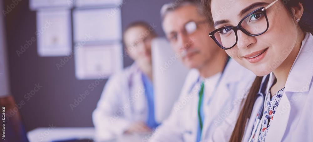Serious medical team using a laptop in a bright office Serious medical team using a laptop in a bright office
