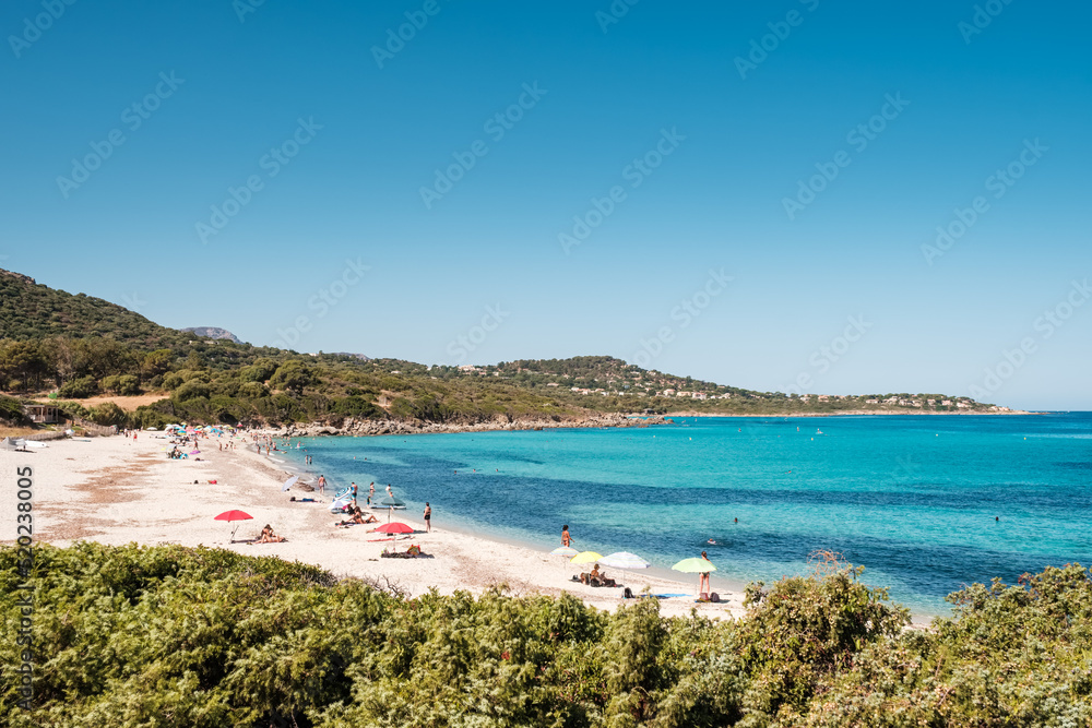 Holidaymakers enjoy the turquoise Mediterranean sea at Bodri beach in the Balagne region of Corsica
