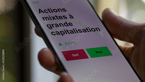 Un investisseur analyse un fonds etf actions mixtes à grande capitalisation sur un graphique. Un téléphone affiche le cours de l'ETF. Texte en français francais Actions mixtes à grande capitalisation