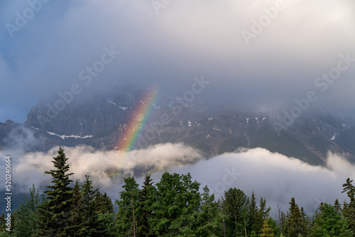 Colorful rainbow in the mountains above Canmore, Alberta in the Canadian Rockies on a summer morning © MelissaMN