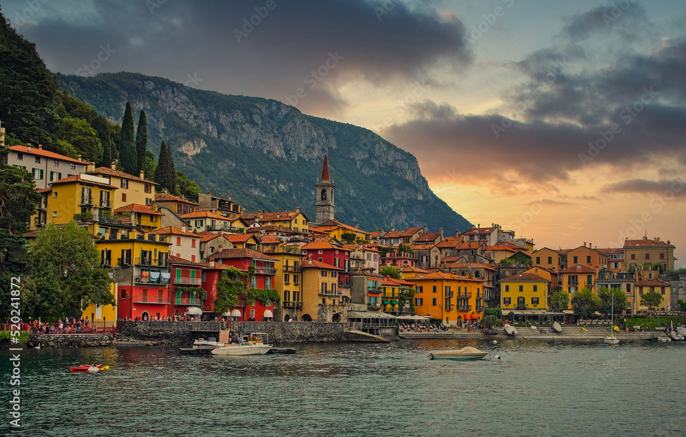 This is the romantic village Varenna, at the north italian lake Como in the Lombardy at sunset. The picture was taken from the boat so you can see the mountains from the Alps in the background.