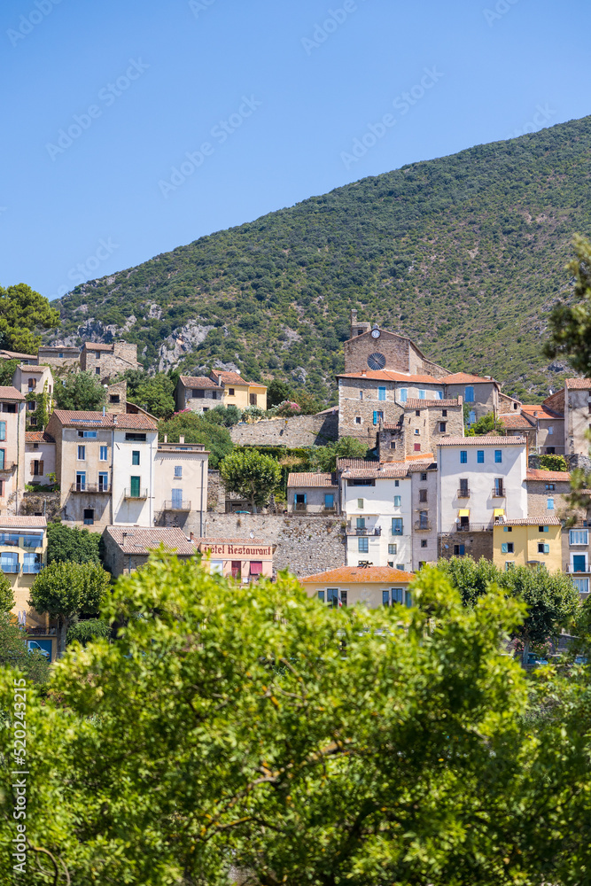 Vue estivale sur le village de Roquebrun depuis les berges de l'Orb