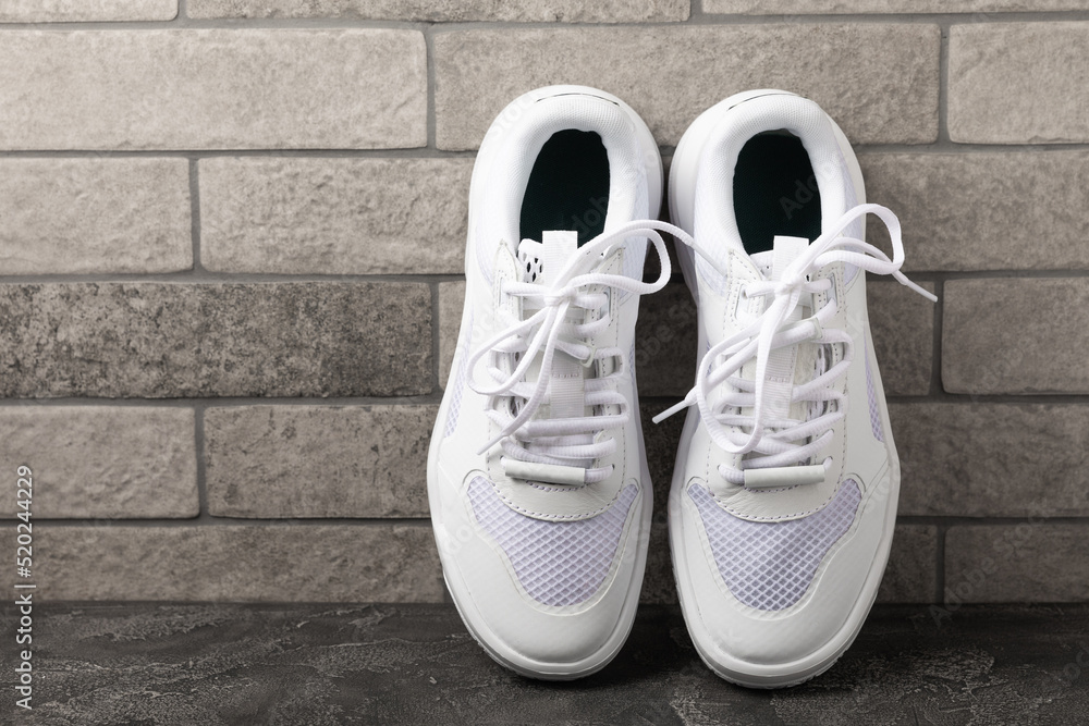 White sneakers on a black textured background.Fashion.UNISEX. Sports shoes sneakers for active lifestyle.Product photo and levitation concept.Street style.Copy space.Place for text.