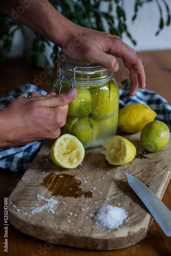 Closing the canning jar filled with traditional Moroccan salted lemons