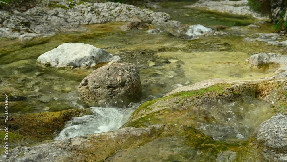 Detail of a small stream in the mountains with clear and clean water Detail of a small stream in the mountains with clear and clean water