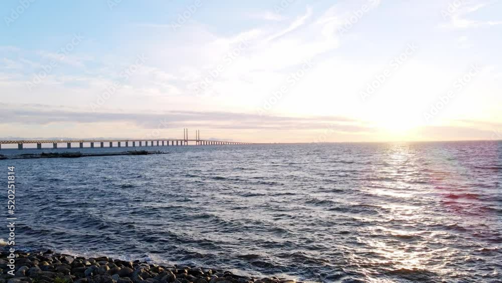 Aerial view of Oresund bridge at the sunset in summer. Cinematic shot of long tunnel and bridge between Sweden and Denmark. Oresund bridge shot from the shore. High quality 4k footage Aerial view of Oresund bridge at the sunset in summer. Cinematic shot of long tunnel and bridge between Sweden and Denmark. Oresund bridge shot from the shore. High quality 4k footage