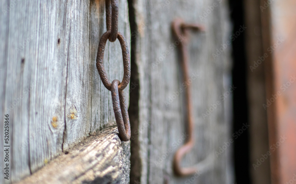 Isolated old rusty door latch on a wooden door. Close-up. Problematic weathered panels. Old wall texture background. Detail of an old wooden door with a rusty door latch. Isolated old rusty door latch on a wooden door. Close-up. Problematic weathered panels. Old wall texture background. Detail of an old wooden door with a rusty door latch.