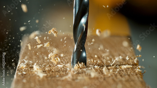 Freeze motion of a drill bit drilling into wood, macro shot