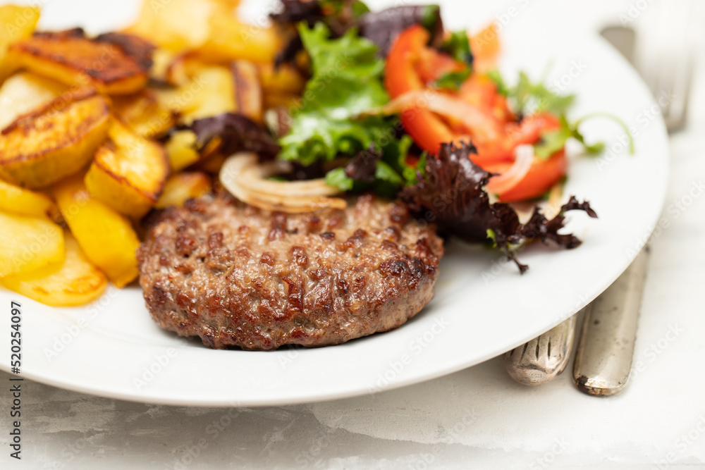 fresh grilled hamburgers with potato and salad on plate fresh grilled hamburgers with potato and salad on plate