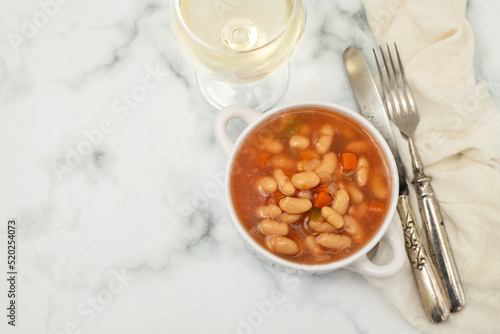 boiled white beans with vegetables and sauce on white bowl
