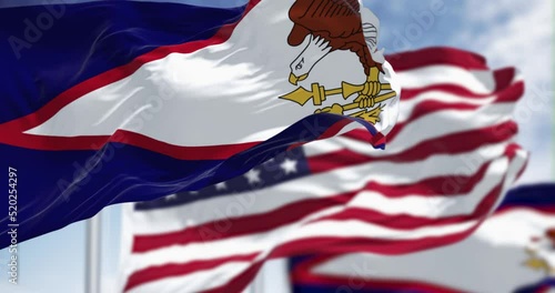 The American Samoa flags waving along with the national flag of the USA photo