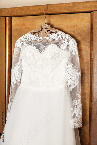 Lace wedding dress hanging on the closet © tsezarina