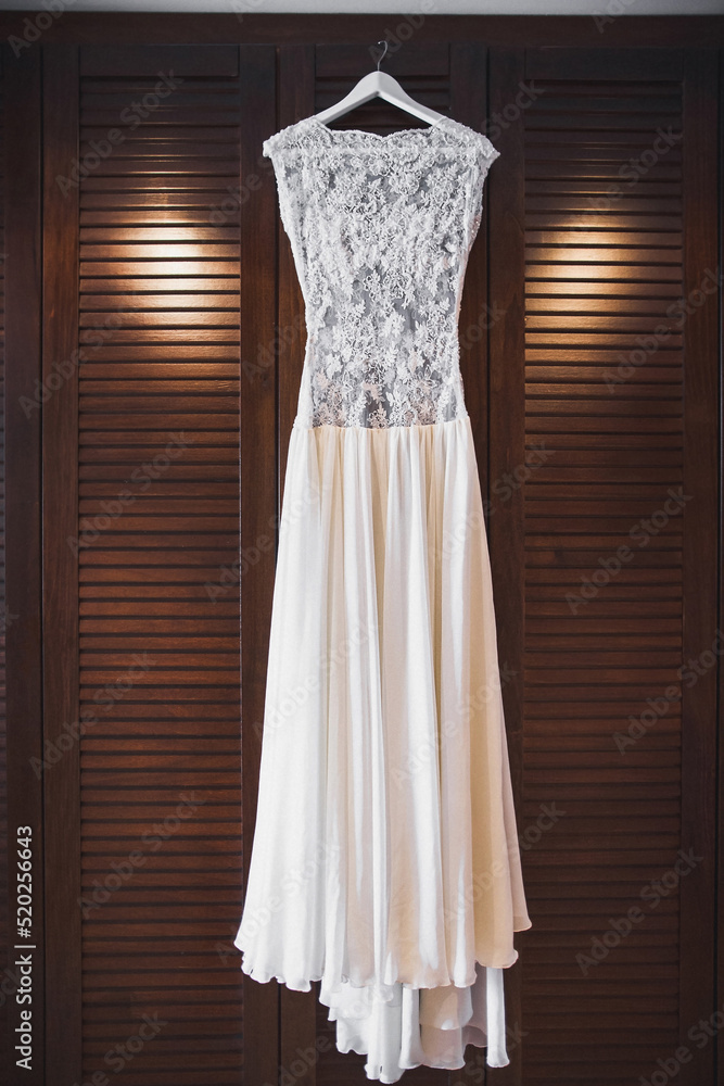 Wedding dress hanging on a wooden wardrobe Wedding dress hanging on a wooden wardrobe