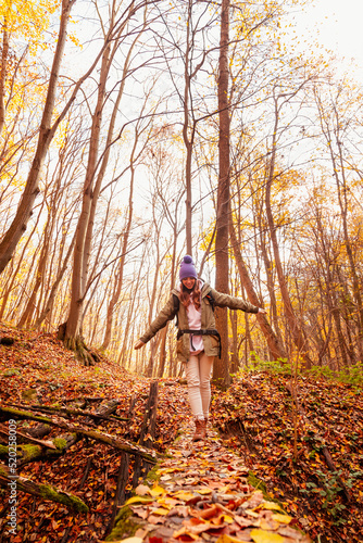 Woman walking by an autumn forest path