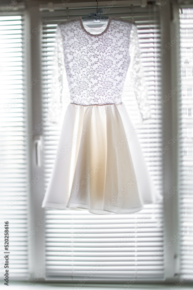 Short wedding dress hanging on the window Short wedding dress hanging on the window