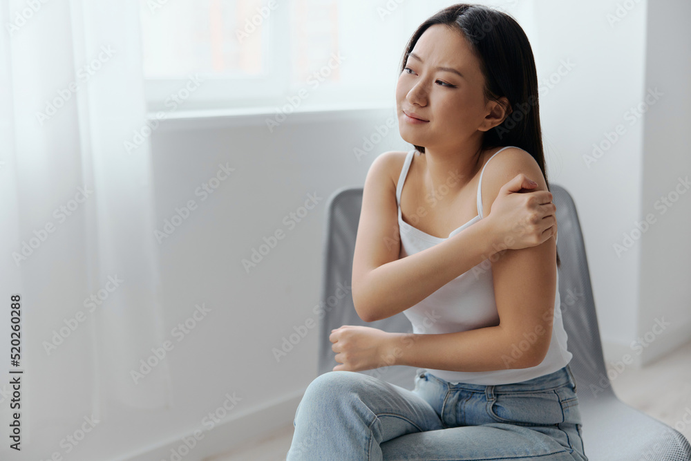 Suffering from neuralgia after sleeping in the wrong position tanned beautiful young Asian woman touching painful shoulder at home living room. Injuries Poor health Illness concept. Cool offer Banner Suffering from neuralgia after sleeping in the wrong position tanned beautiful young Asian woman touching painful shoulder at home living room. Injuries Poor health Illness concept. Cool offer Banner