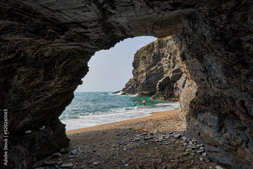 Obraz premium Cave by the sea and man taking a bath. Calblanque Regional Park in Murcia