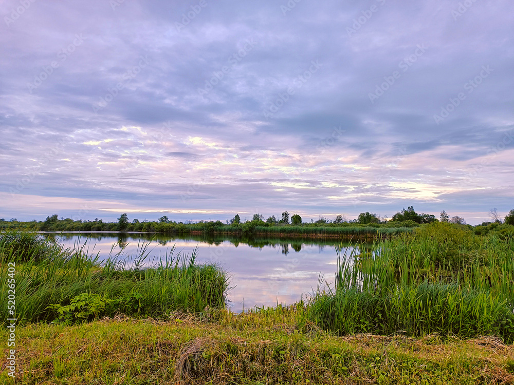 Calm water on lake. Storm Rainy weather. Summer overcast sky. Dramatic landscape, cloudy day.