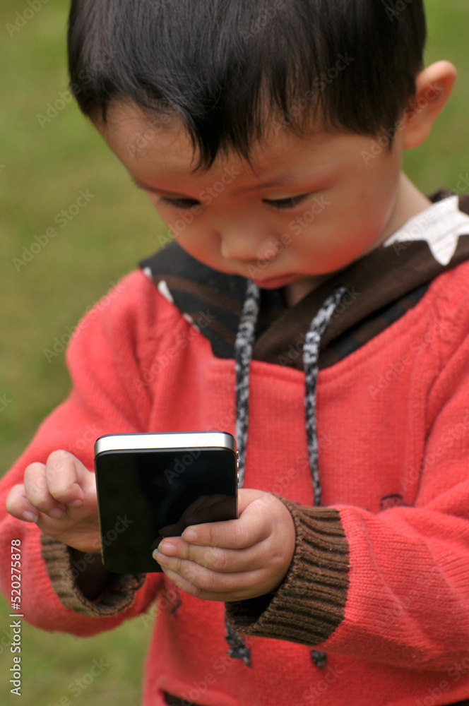 a chinese boy using mobile phone a chinese boy using mobile phone