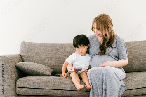 子供とスマホを見る妊娠中の日本人女性 