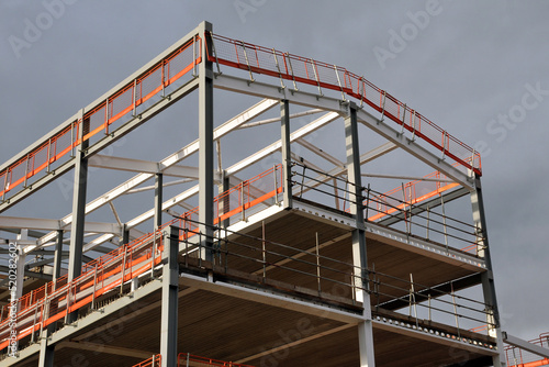 steel frame and roof of a building under construction with orang