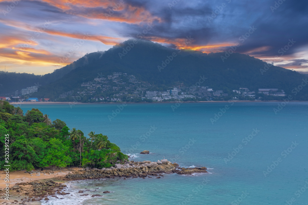 Obraz premium Colourful Skies Sunset over Head Laem Sing Beach in Phuket Thailand. This Lovely island waters are turquoise blue waters, lush green mountains colourful skies and beautiful views of Pa Tong Patong