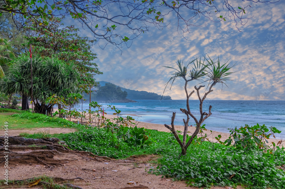 Fototapeta premium Colourful Skies Sunset over Surin Beach in Phuket Thailand. This Lovely island waters are turquoise blue waters, lush green mountains colourful skies and beautiful views of Pa Tong Patong