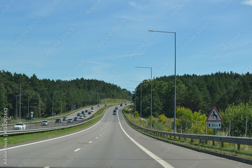 Freeway in the suburban part of Vilnius, Lithuania. Sign warning about the sudden appearance of animals on the road.
