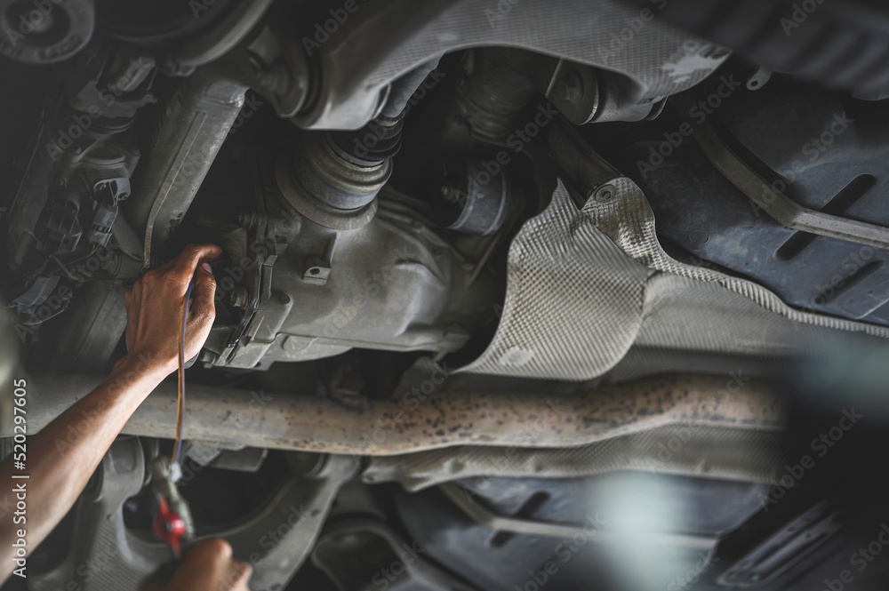 Auto mechanic filling rear differential fluid ,rear differential fluid