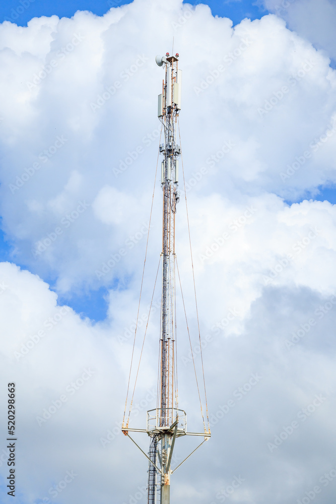 Telecommunication tower of 4G and 5G cellular. Macro Base Station. 5G radio network telecommunication equipment with radio modules and smart antennas mounted on a metal against cloulds sky background. Telecommunication tower of 4G and 5G cellular. Macro Base Station. 5G radio network telecommunication equipment with radio modules and smart antennas mounted on a metal against cloulds sky background.