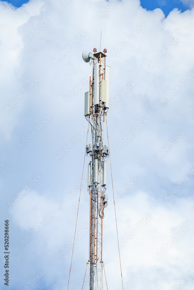 Telecommunication tower of 4G and 5G cellular. Macro Base Station. 5G radio network telecommunication equipment with radio modules and smart antennas mounted on a metal against cloulds sky background. Telecommunication tower of 4G and 5G cellular. Macro Base Station. 5G radio network telecommunication equipment with radio modules and smart antennas mounted on a metal against cloulds sky background.