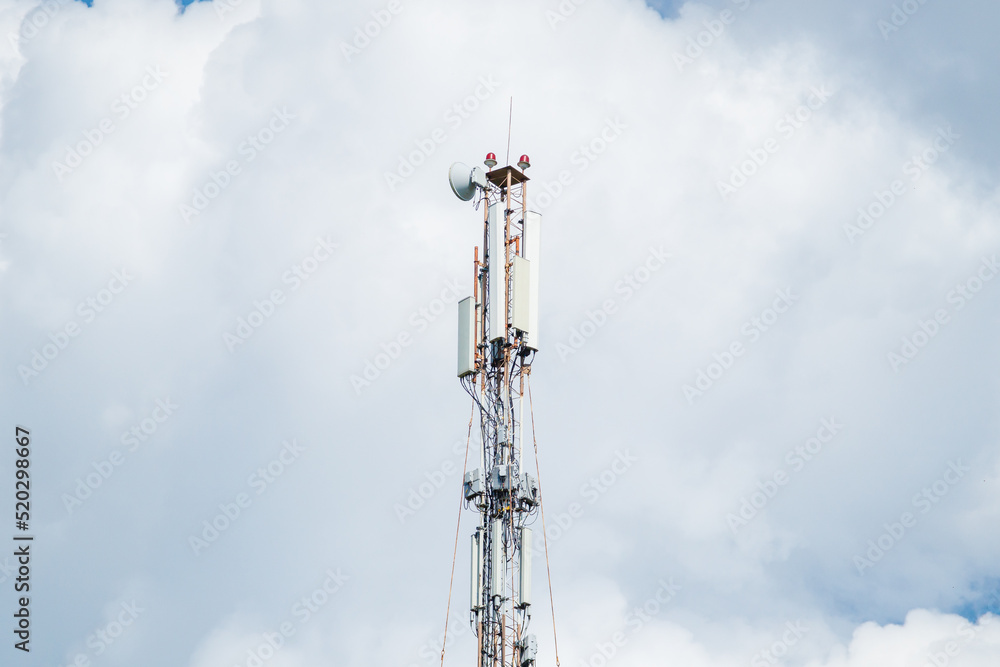 Telecommunication tower of 4G and 5G cellular. Macro Base Station. 5G radio network telecommunication equipment with radio modules and smart antennas mounted on a metal against cloulds sky background. Telecommunication tower of 4G and 5G cellular. Macro Base Station. 5G radio network telecommunication equipment with radio modules and smart antennas mounted on a metal against cloulds sky background.