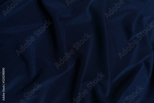 Blue crepe satin crumpled or wavy fabric texture background. Abstract linen cloth soft waves. Silk fabric. Smooth elegant luxury cloth texture. Concept for banner or advertisement.