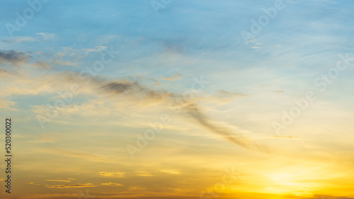 Nature illustration of golden sky at dawn with clouds and sun shining brightly