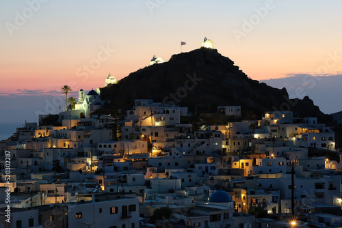 Panoramic view of the picturesque illuminated island of Ios in Greece while the sun is setting