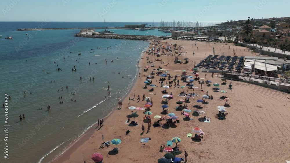flying backward along crowded beach of Marina di Ragusa Sicily flying backward along crowded beach of Marina di Ragusa Sicily