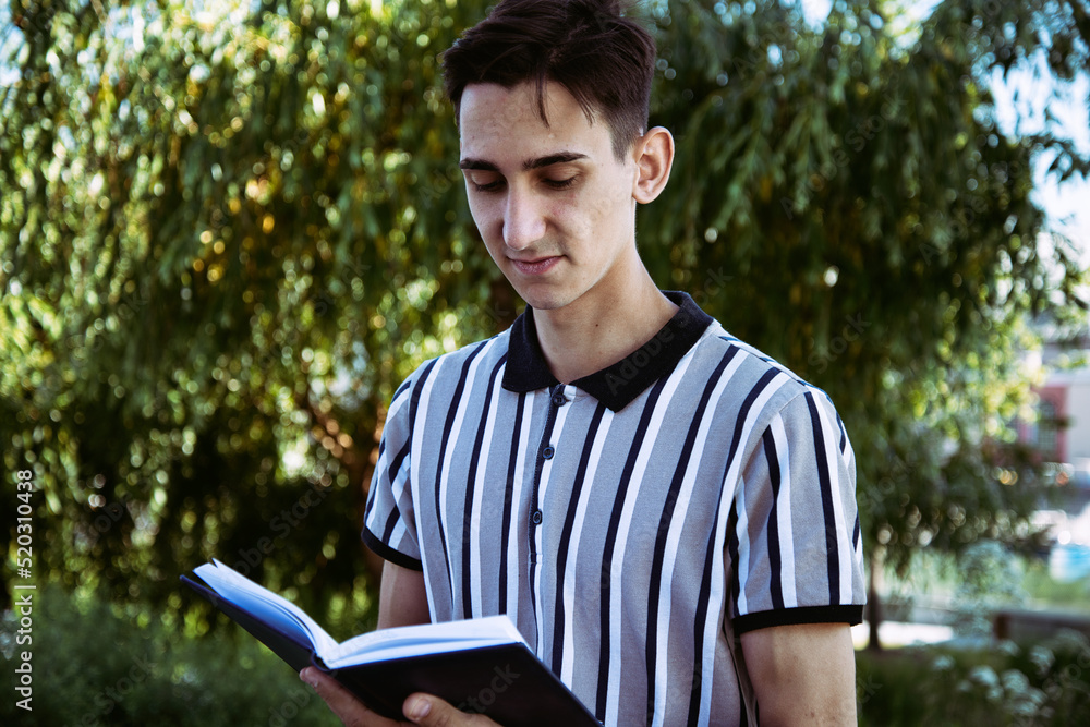 Fototapeta premium Education and entertainment. Young attractive student with a book. Happy man. 