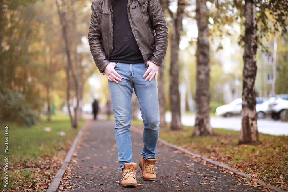 Autumn concept. Pedestrian feet on the road. Autumn leaves on the footpath. Autumn concept. Pedestrian feet on the road. Autumn leaves on the footpath.