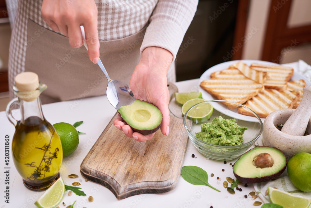 Making avocado toast - Woman peeling ripe halved avocado
