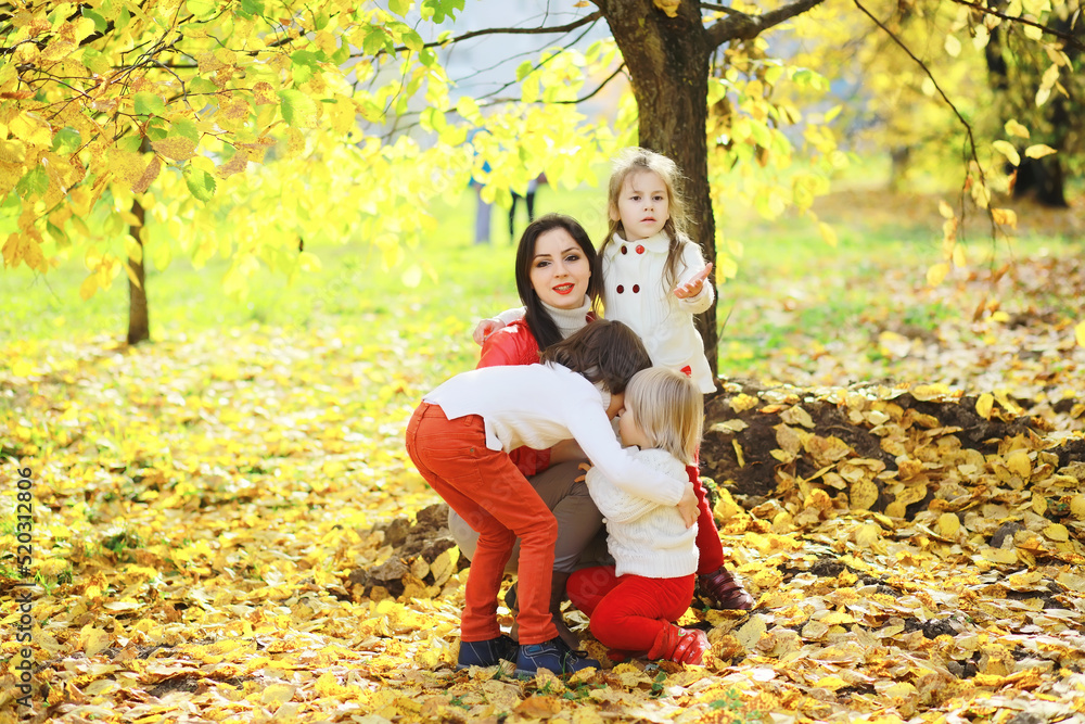 Children for a walk in the autumn park. Leaf fall in the park. Family. Fall. Happiness.