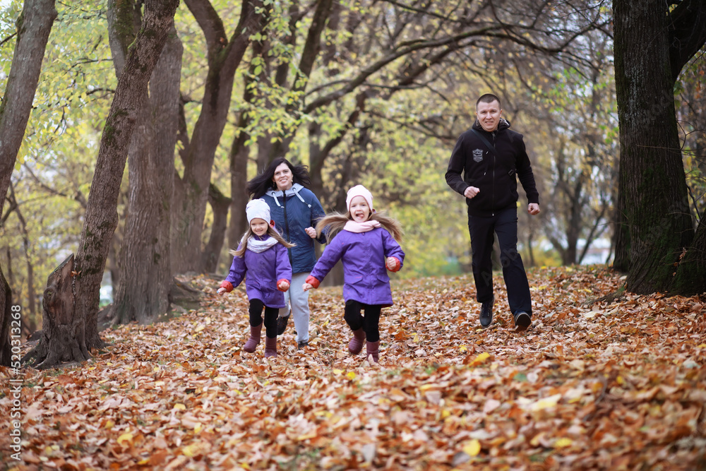 Young family on a walk in the autumn park on a sunny day. Happiness to be together. Young family on a walk in the autumn park on a sunny day. Happiness to be together.