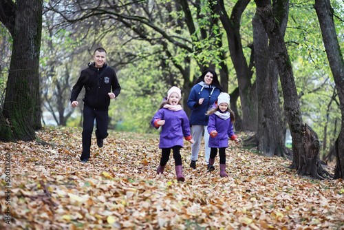 Leaf fall in the park. Children for a walk in the autumn park. Family. Fall. Happiness. © alexkich