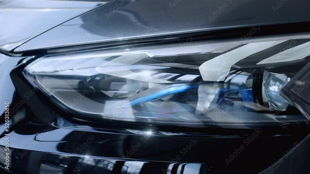 Close up of details of headlights of anonymous prestigious black luxury modern car. Concept of passion for driving cars, car dealerships,luxury cars. Shot in 4K. Close up of details of headlights of anonymous prestigious black luxury modern car. Concept of passion for driving cars, car dealerships,luxury cars. Shot in 4K.