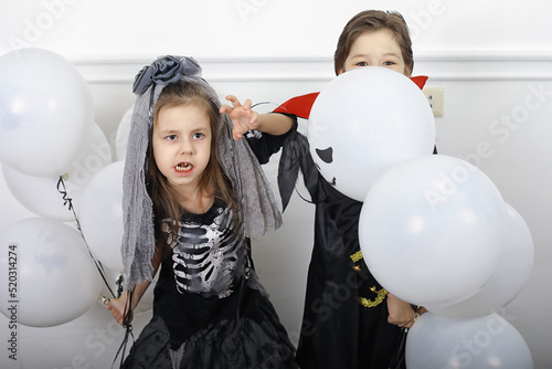 Happy family with children in costumes of witch and vampire in a house in holiday Halloween