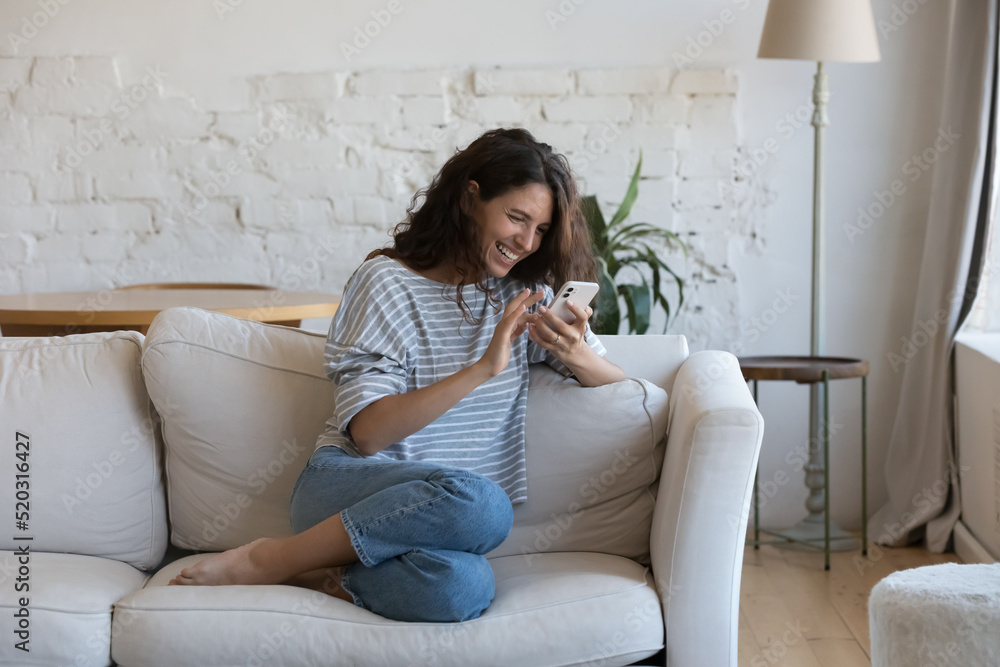 Excited happy young adult woman reading message on mobile phone, getting good news on screen, smiling, laughing, talking on video call, chatting on Internet, using online app. Communication concept Excited happy young adult woman reading message on mobile phone, getting good news on screen, smiling, laughing, talking on video call, chatting on Internet, using online app. Communication concept
